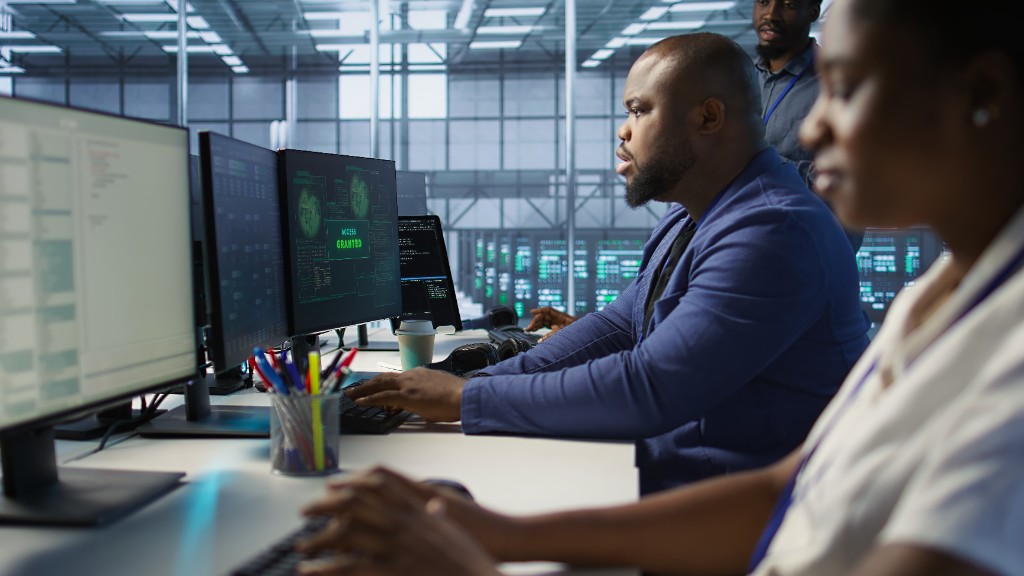A team monitoring business systems on screens in a server room
